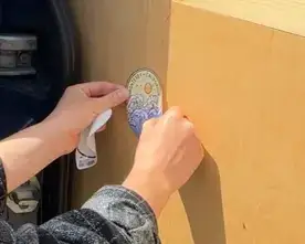 Jess placing a Monterey sticker on Blu's sticker wall