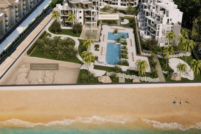 Aerial view of a residential complex with swimming pools, gardens, and the beach with the sea.