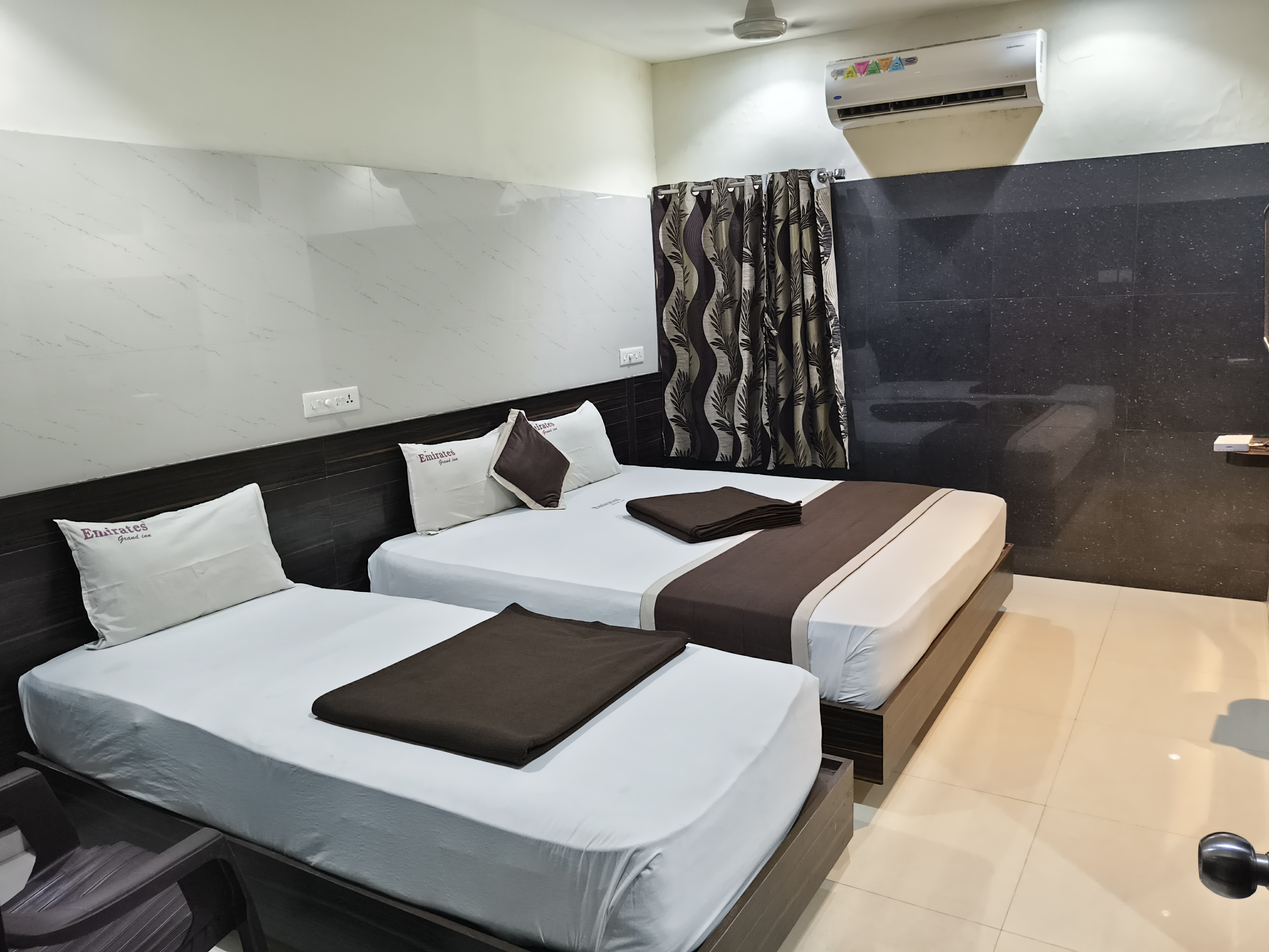 Comfortable twin bedroom with modern furnishings at Emirates Grand Inn