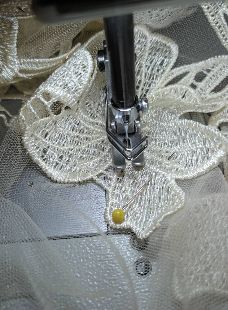 A person sewing on a sewing machine.