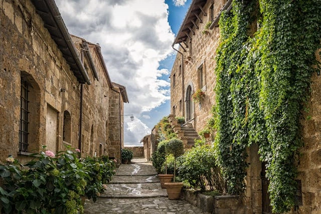 Vicoli di un borgo tipico italiano adornati da piante, fiori e balconi in ferro battuto