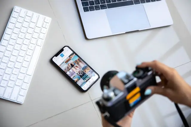 Telefono con social aperti e fotocamera attiva, rappresentazione della FOMO da viaggio