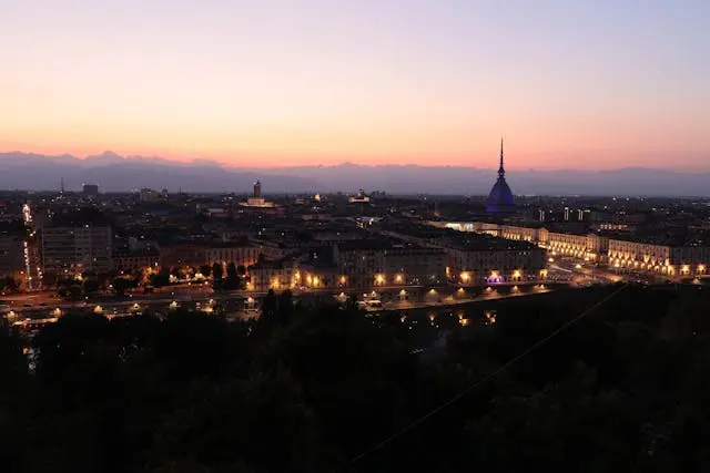 Il ponte sul fiume Po a Torino al tramonto, con il profilo della città in lontananza.