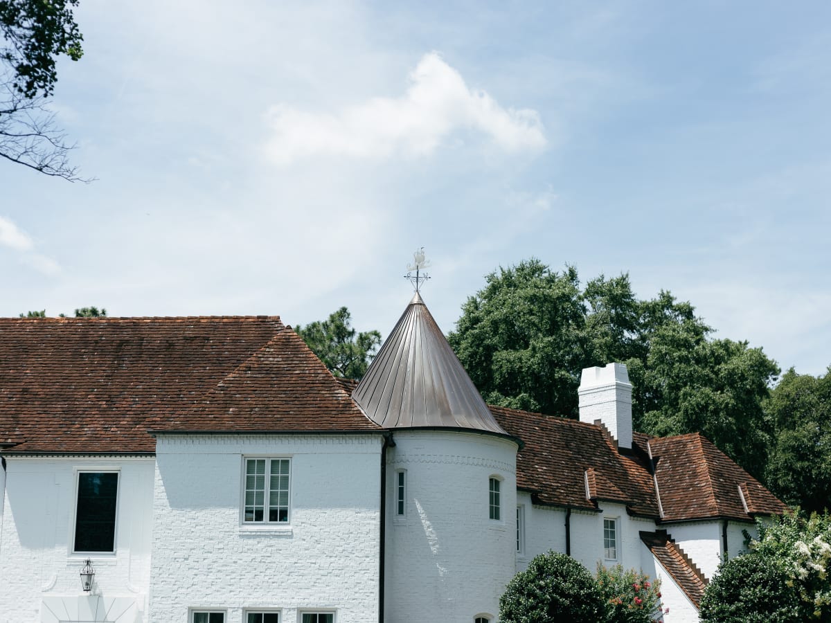 Clay tile roof and copper turret on a white Charleston home