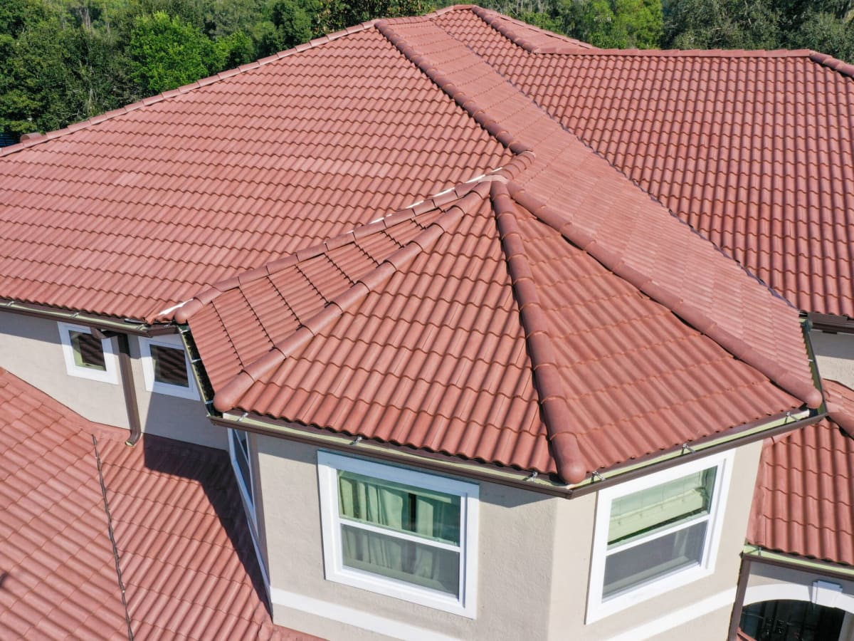 Red clay tile roof with hip and valley details on a stucco home