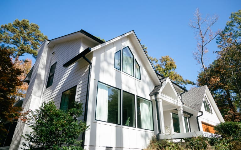 Two-story home with crisp white siding and new black-framed windows