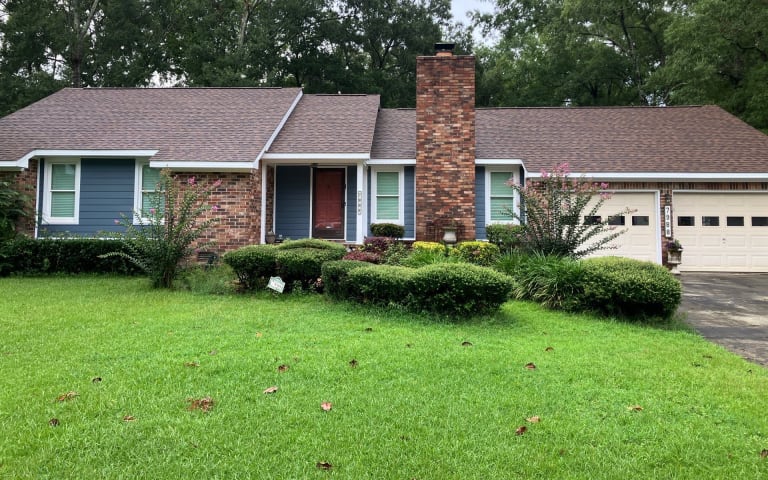 Brick ranch home with a new asphalt shingle roof and a wide green lawn