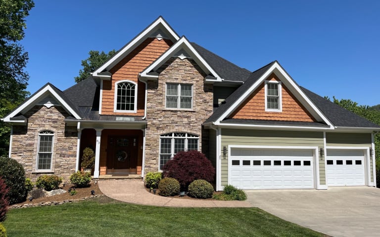 Stone and cedar mountain home with a new black architectural shingle roof