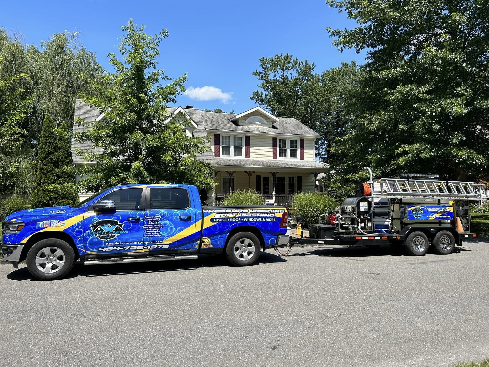 Professional pressure washing truck and trailer setup at residential property