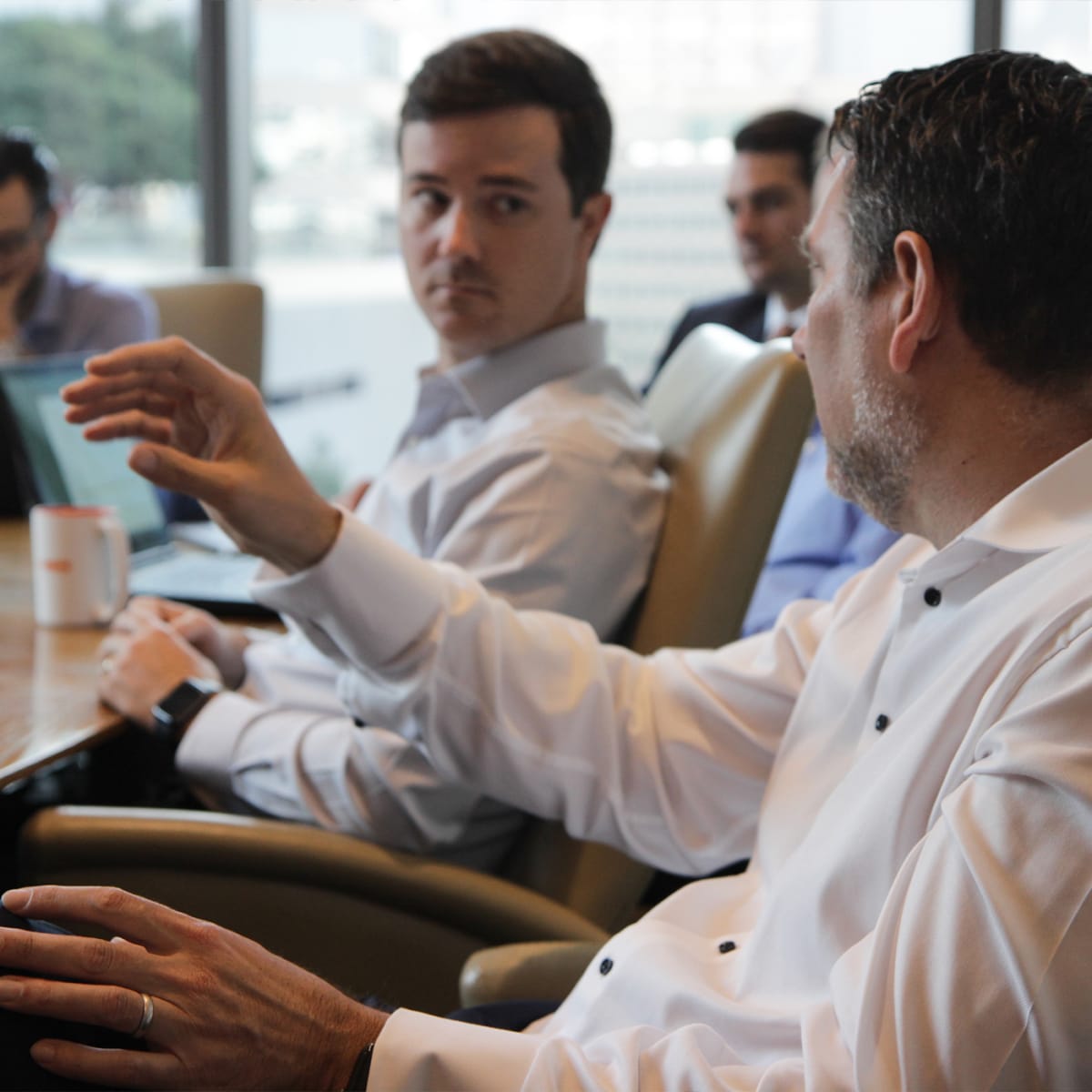 Professional handshake over a signing table in a bright corporate office board room