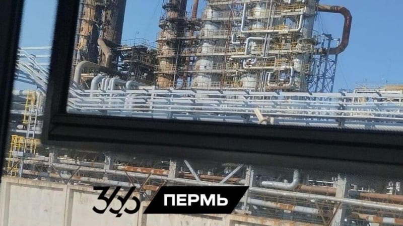 Oil refinery infrastructure in Perm, Russia, photographed through a window, showing distillation columns, piping, and industrial structures. A watermark reads '365 Пермь'.