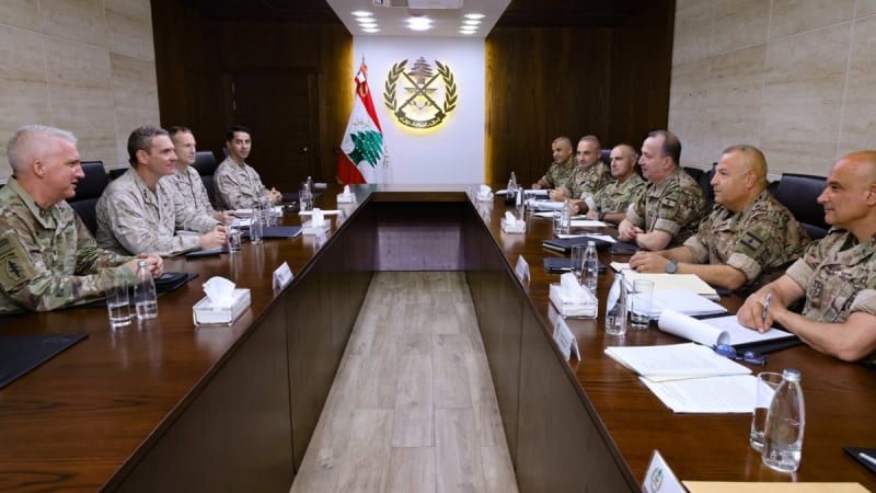 Military officials from the U.S. and Lebanese Armed Forces seated around a large conference table during a bilateral meeting at a Lebanese military facility, with the Lebanese Army emblem and flag displayed on the back wall.