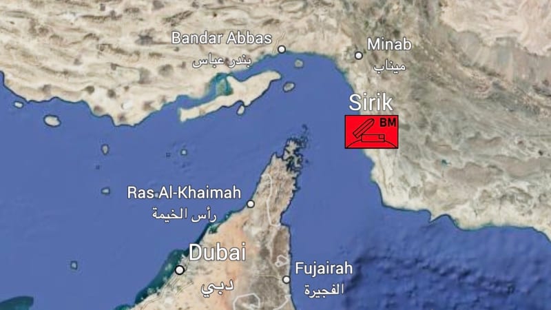 Satellite map view of the Strait of Hormuz region showing the UAE (Dubai, Ras Al-Khaimah, Fujairah, Al Ain), Oman (Sohar, Muscat/Seeb), and southern Iran (Bandar Abbas, Minab, Sirik) with a red marker icon near Sirik.