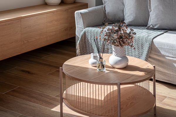 Cozy sofa with knitted throw blanket, soft pillows, and decorative items on a small coffee table.