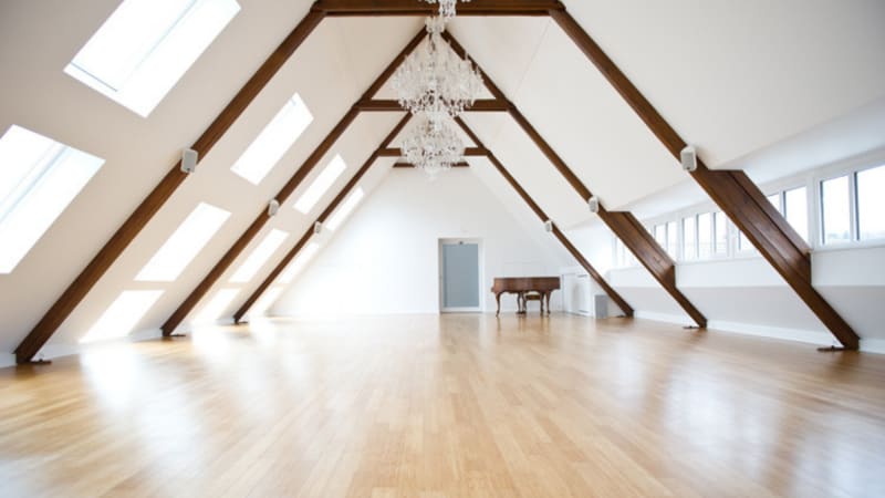 Seminarraum Purna mit Dachschrägen, Kristallleuchter und Klavier im Seminarhaus Sampurna