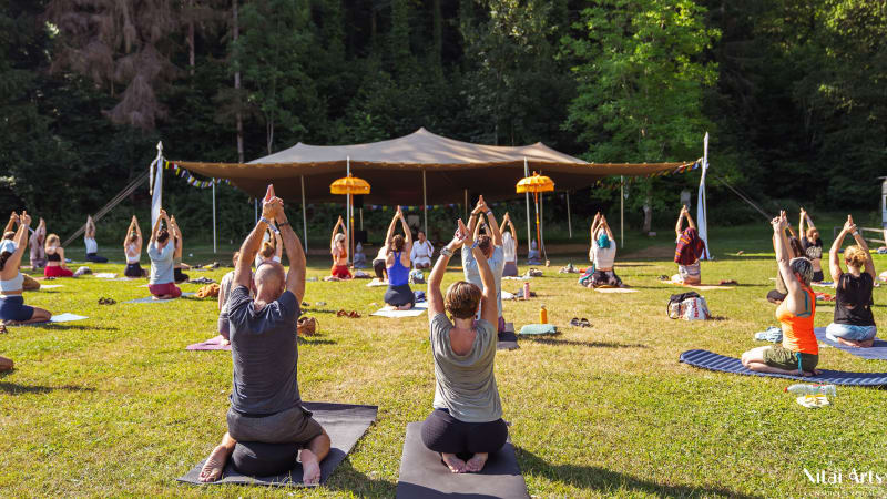 Teilnehmer des Summer Celebration praktizieren Yoga in der Natur
