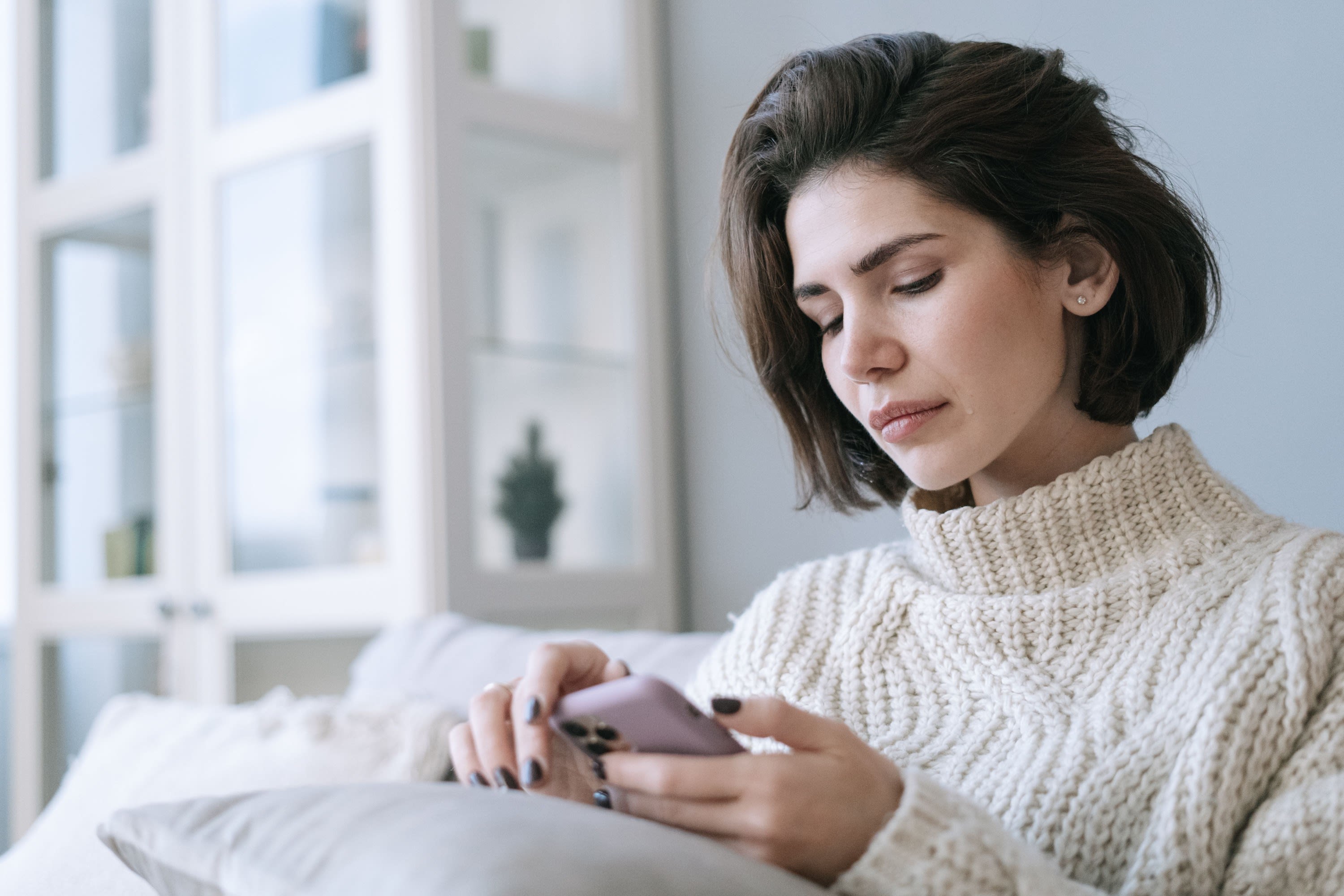 Woman at home reading a message on her phone
