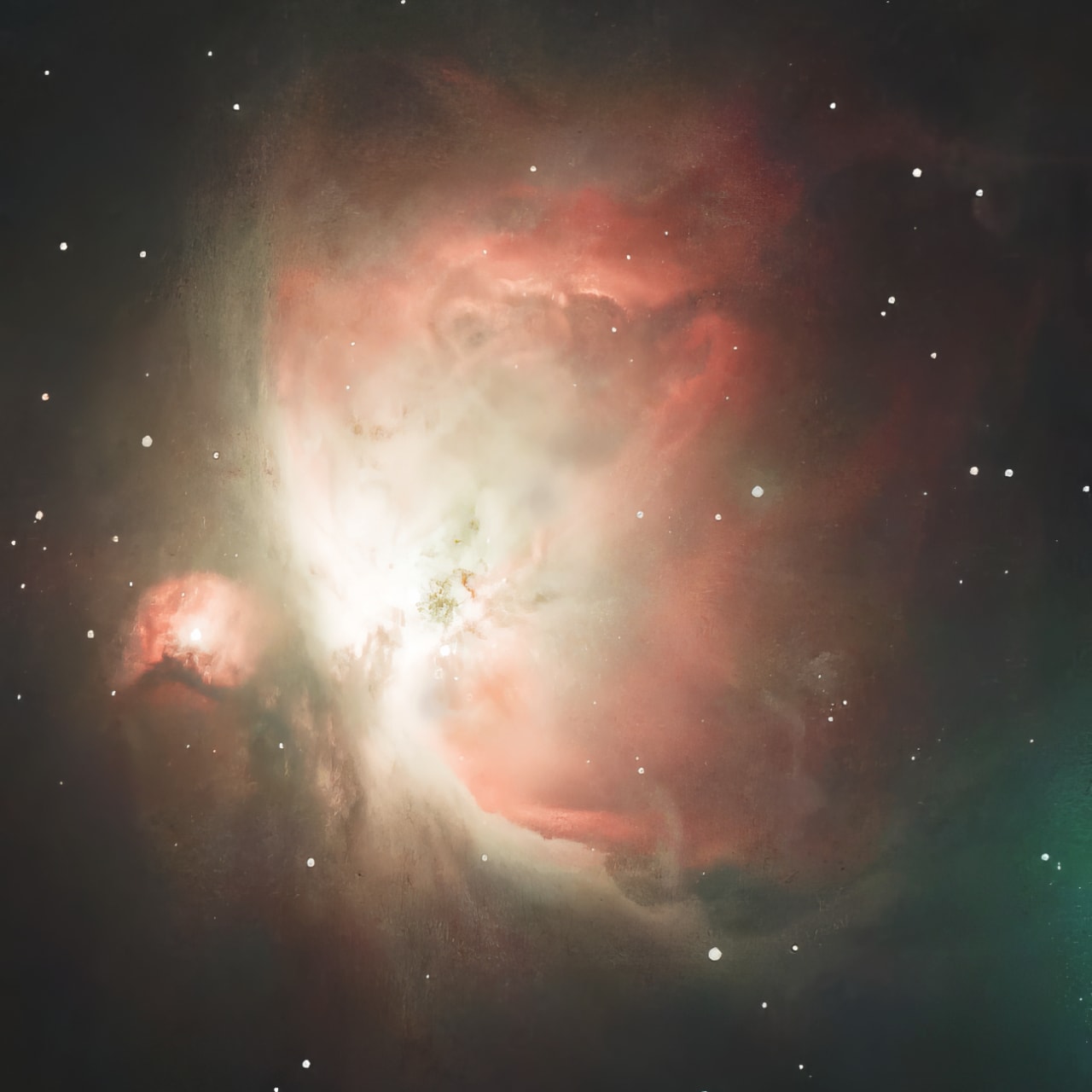 The Orion Nebula: a bright white core wrapped in red and pink clouds of gas, with scattered stars