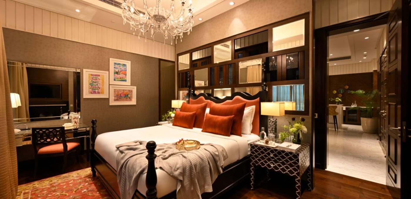 Chambre du Taj Santacruz à Mumbai, tête de lit sculptée et coussins orangés