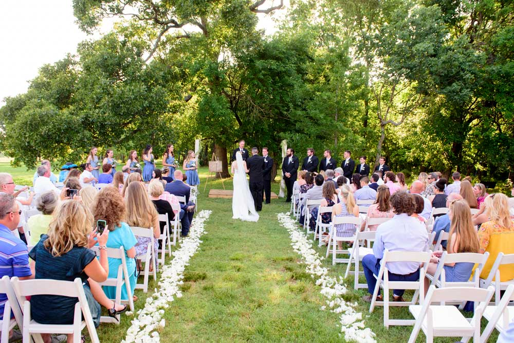 summer outdoor wedding ceremony with trees in background