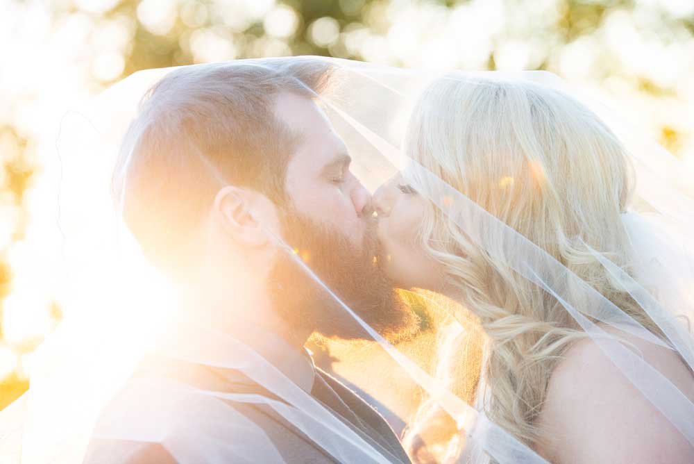 bride and groom under veil