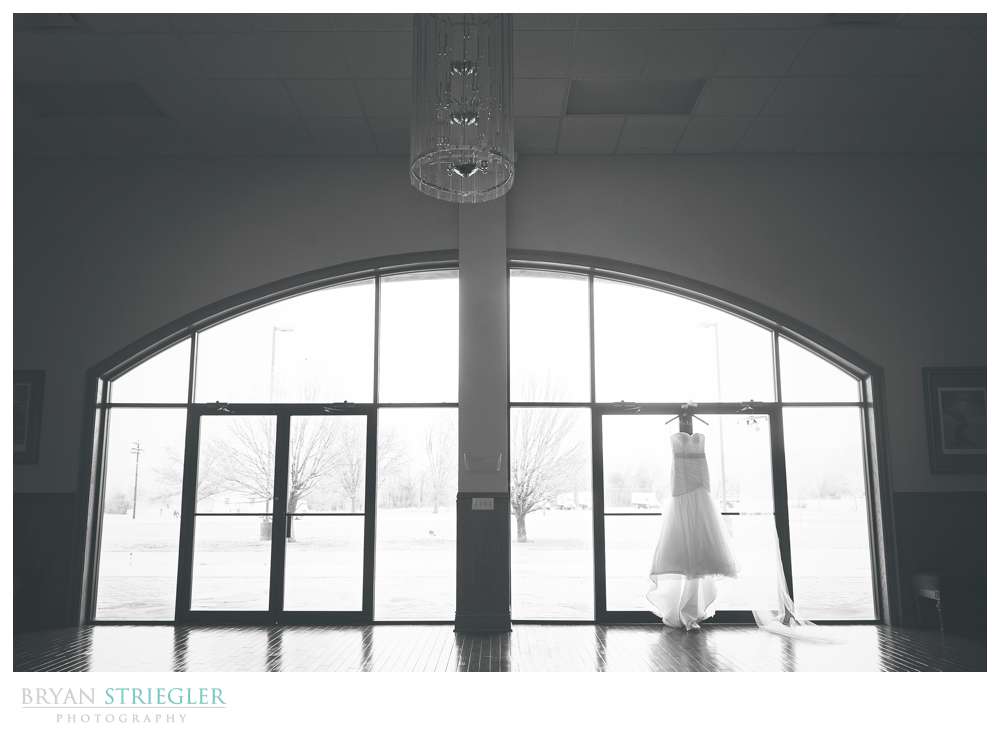 wedding dress hanging in doorway