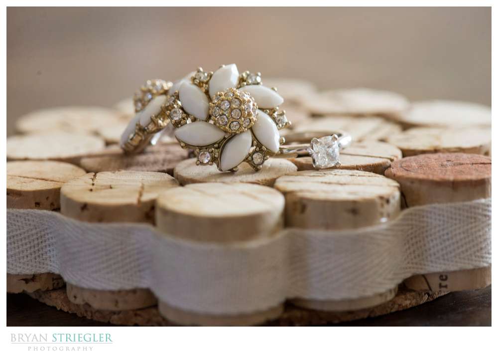earrings and engagement ring together on wine corks