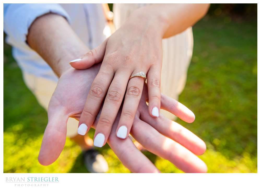 couples hands together with engagement ring