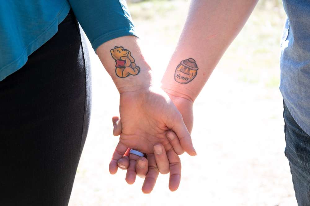 Couple with Winnie the Pooh tattoos