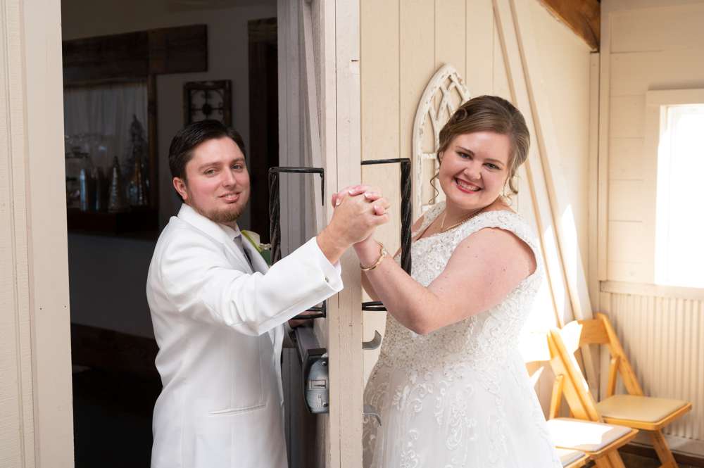 wedding couple holding hands around door