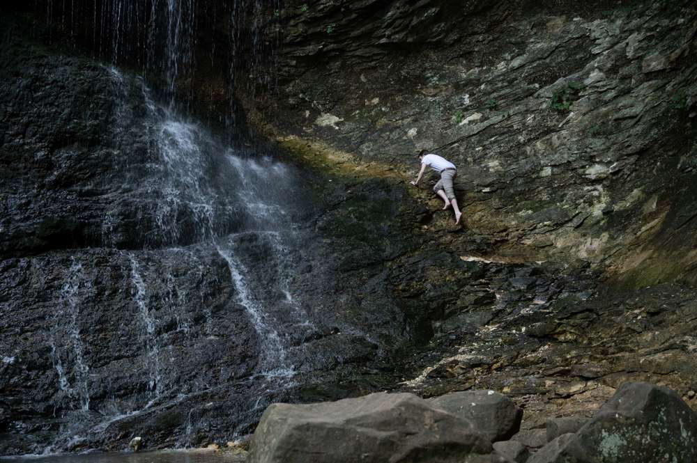 guy climbing waterfall