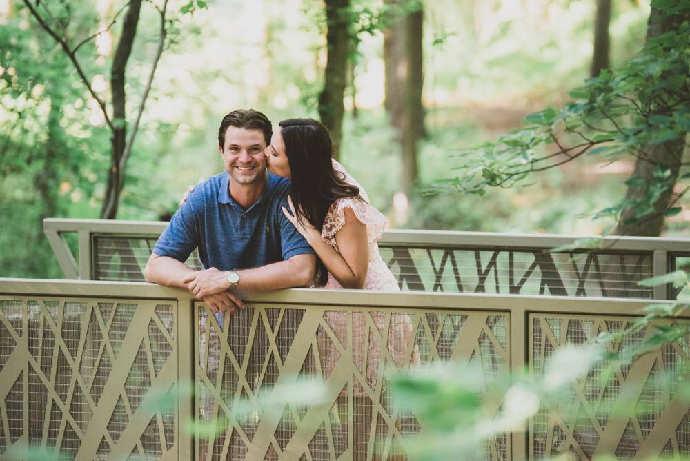 couple leaning on bridge