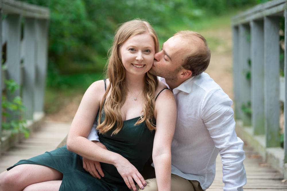 couple sitting on a bridge for engagement session