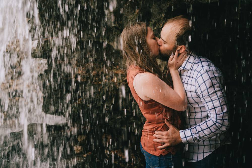 engaged couple under a waterfall