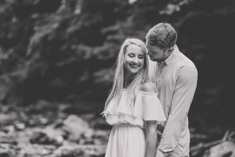 black and white engagement photo in creek
