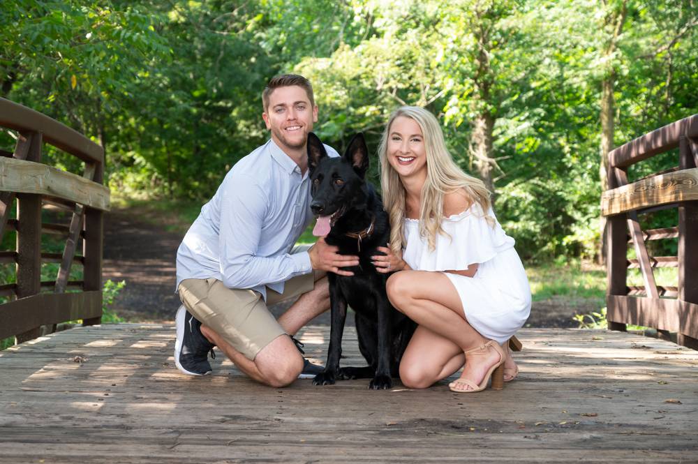 couple with dog on bridge