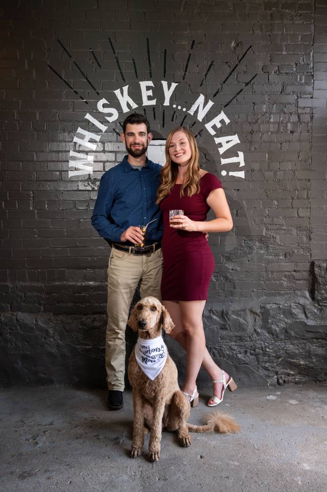 couple standing by logo of whiskey bar