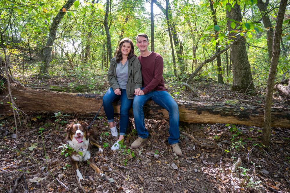 engagement session with couple sitting on log