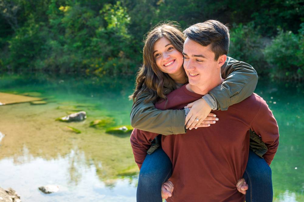 couple in front of blue green creek
