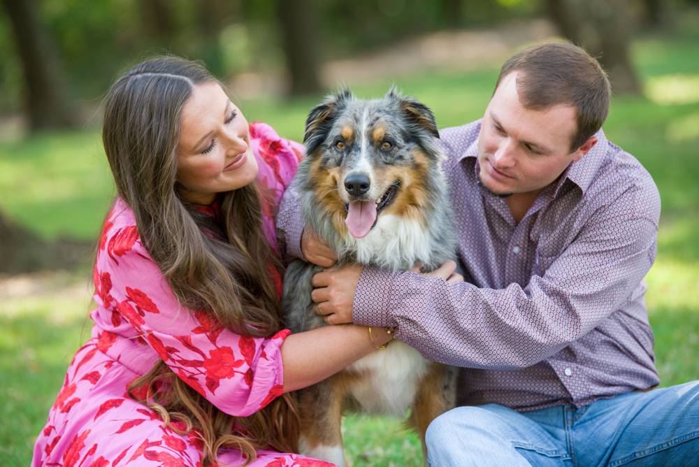 engaged couple hugging dog