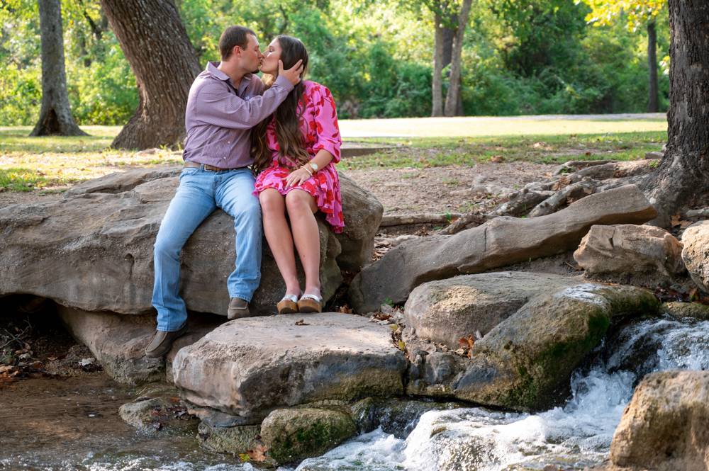 couple kissing near creek