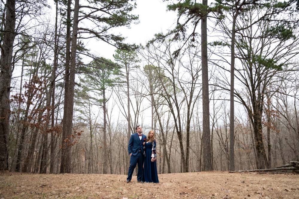 wide shot of engaged couple in woods 