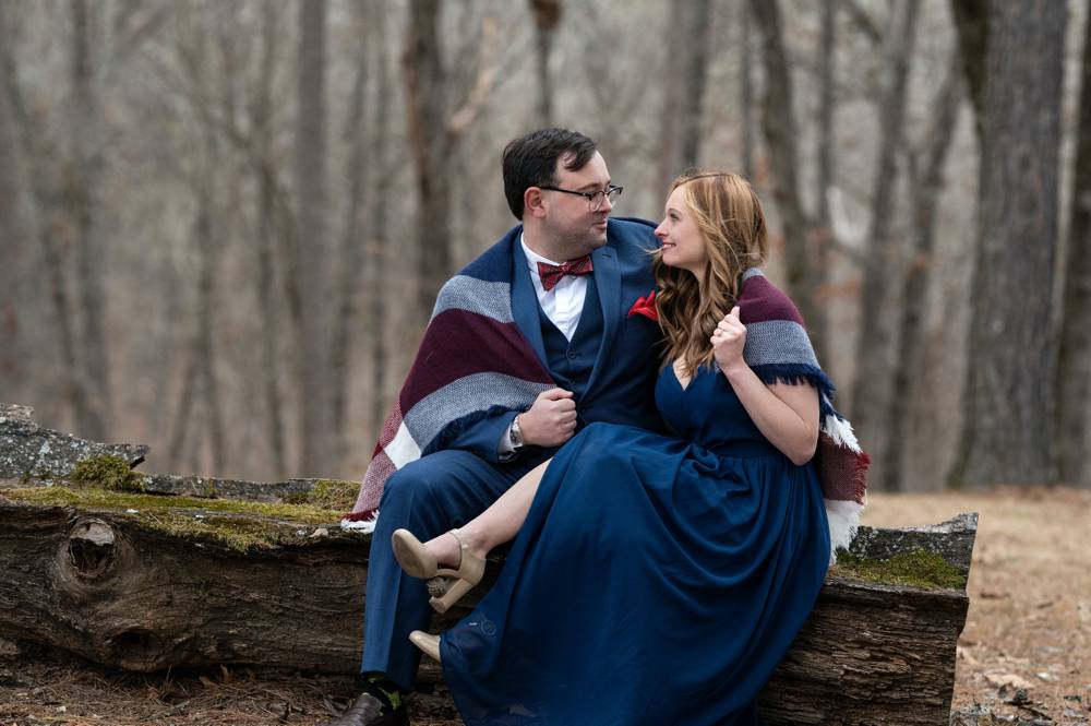engagement session in the woods sitting on log