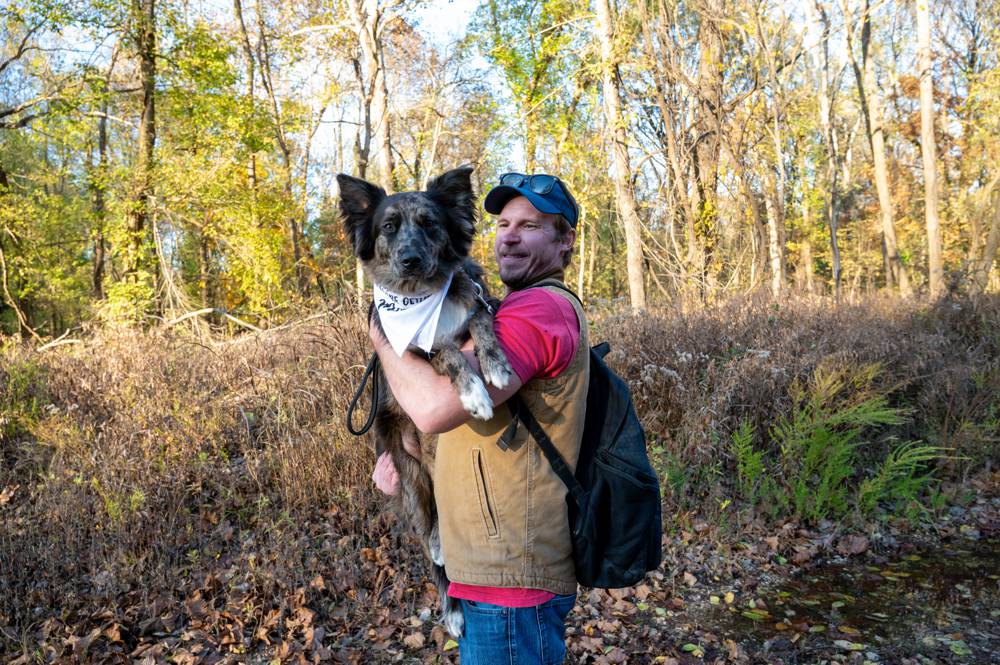 helper carrying dog during engagement shoot