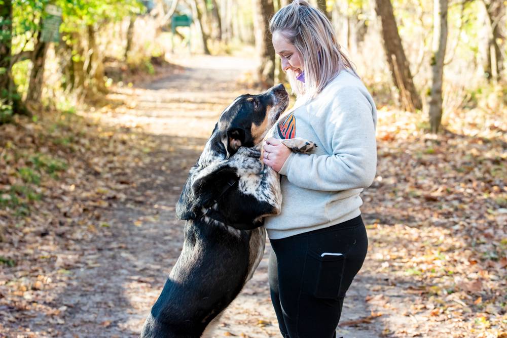 friend helping with dogs during engagement shoot