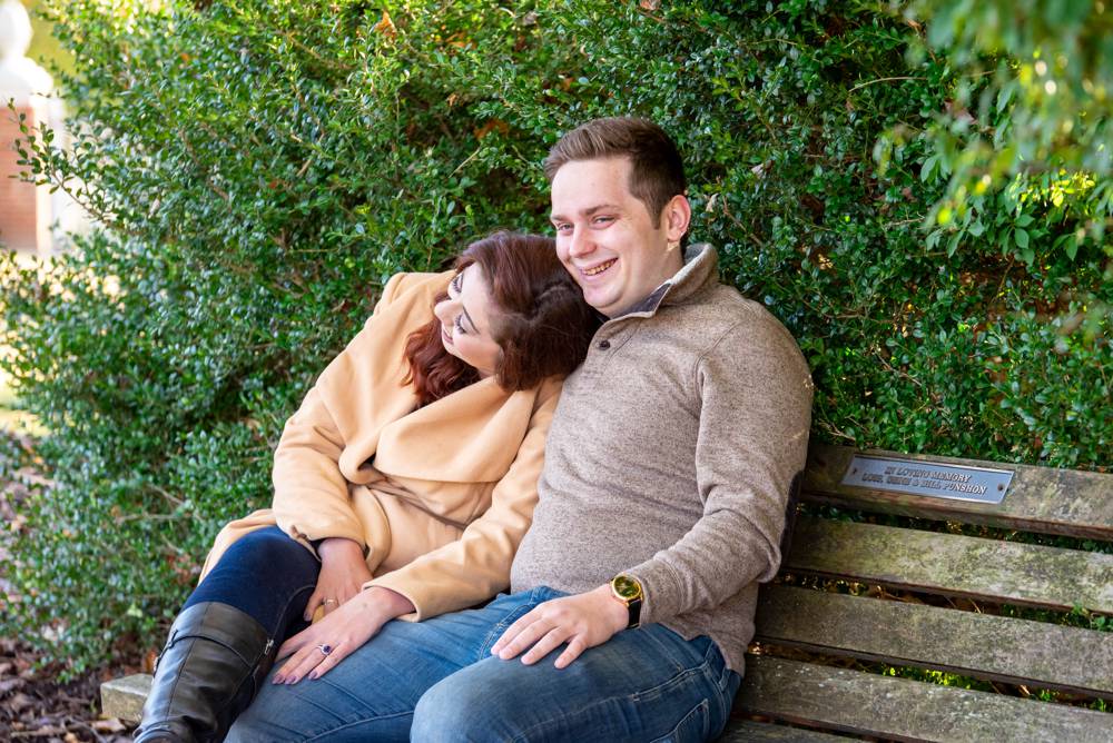 couple laughing and sitting on bench