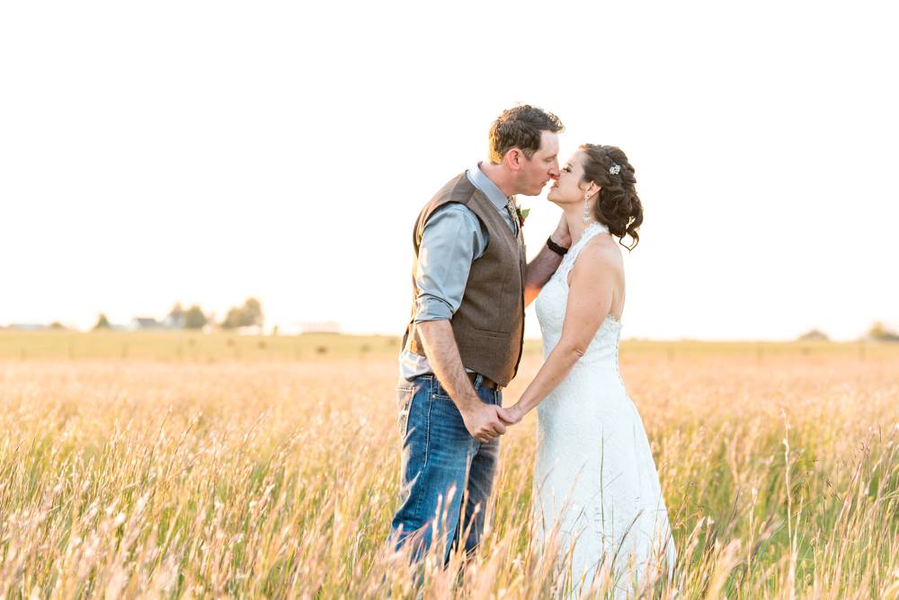 sunlit field with bride and groom