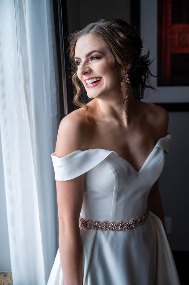 bride laughing in front of window at Mayo Hotel