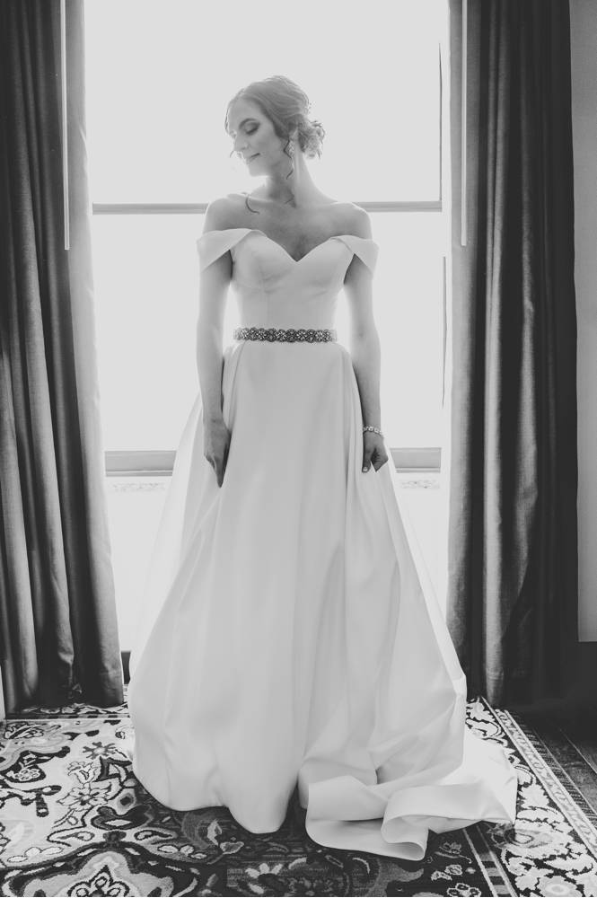 black and white of bride in front of window in Mayo Hotel