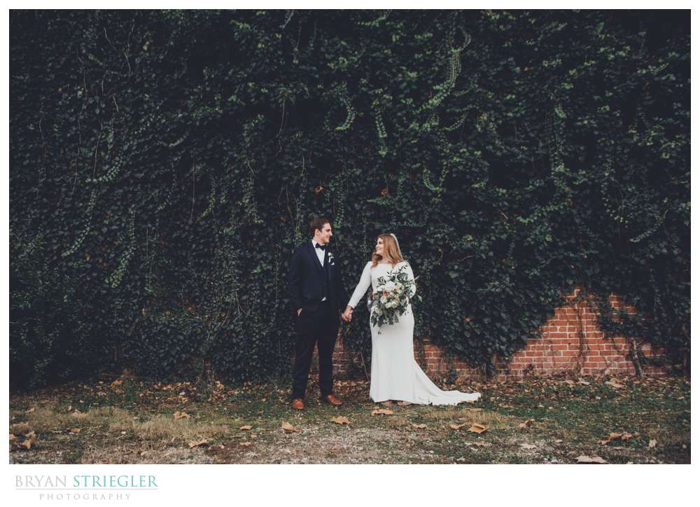 wedding couple in front of giant ivy wall